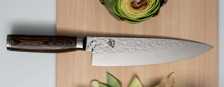 Shun Premier Chef's knife on hinoki cutting board with artichokes